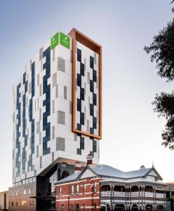 珀斯Holiday Inn West Perth, an IHG Hotel的顶部有钟的建筑物的 ⁇ 染