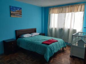 洛哈Amplio y cómodo departamento.的蓝色卧室,配有一张带绿毯的床