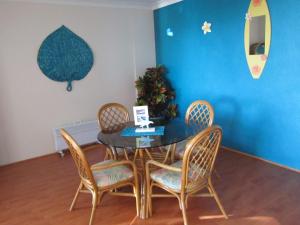 安特兰斯St Tropez Unit 39的一间设有玻璃桌和椅子的用餐室