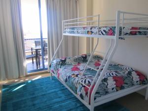 安特兰斯St Tropez Unit 39的一间带两张双层床的卧室和一个阳台