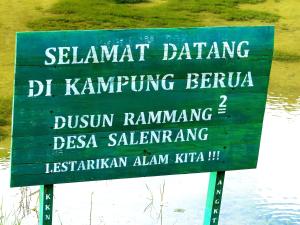 KasijalaKampoeng Karst Rammang Rammang的水体前的绿色标志