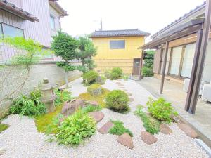 富山ゲストハウス山吹的一座花园,在一座建筑前有岩石和消防栓