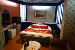 岸和田市沙阿奈恩酒店（仅限成人）的一间卧室配有一张床和一张桌子
