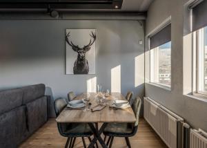 阿克雷里AK Rentals, with hot tubs的用餐室配有桌子,墙上挂着鹿的照片