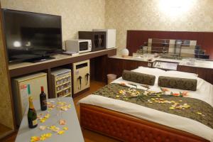 岸和田市沙阿奈恩酒店（仅限成人）的一间卧室配有两张床和一台平面电视