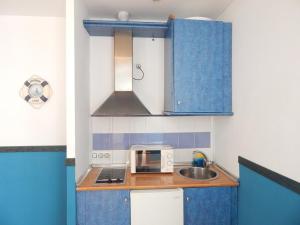 科尼尔-德拉弗龙特拉Apartahotel Playa Conil的一间小厨房,内配蓝色橱柜和水槽