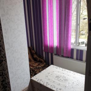索罗卡Apartament cu 2 odai in chirie or.Soroca的一间设有紫色窗帘和窗户的客房
