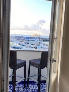 卡普里La Baia di Napoli的阳台配有两把椅子,享有海港景色