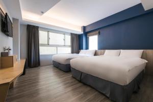 台中市麻雀巢行旅的酒店客房设有两张床和蓝色的墙壁。