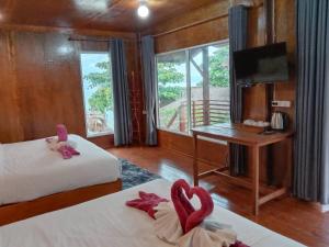 丽贝岛Sea To Moon Lipe的客房设有两张床、一张桌子和一台电视。