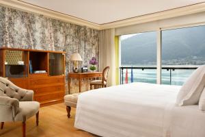 莫尔科泰Swiss Diamond Hotel & Spa的一间卧室设有一张大床和一个大窗户