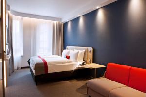达姆施塔特Holiday Inn Express - Darmstadt, an IHG Hotel的酒店客房,配有床和沙发