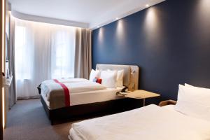 达姆施塔特Holiday Inn Express - Darmstadt, an IHG Hotel的酒店客房设有两张床和蓝色的墙壁。