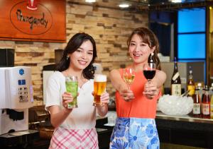 下吕市日下石竹日式旅馆的两个女人拿着啤酒和葡萄酒杯