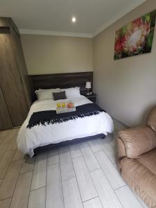 博克斯堡Up21 Guest House的一间卧室配有一张大床和一张沙发