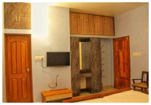 科钦High Island Homestay的客房设有1张床、1台电视和木制橱柜。