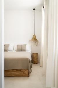 休达德亚Meloussa Boutique Hotel的白色卧室配有一张大床和吊灯