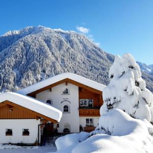 加舒恩Haus Madrisella的一座有雪盖的建筑,背景是一座山