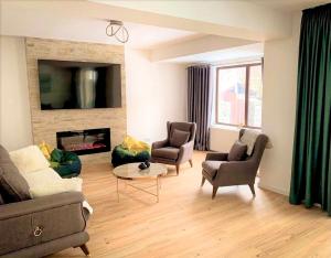 锡纳亚Holiday Home in Sinaia的客厅配有沙发、椅子和壁炉
