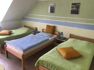 盖尔森基兴Naturfreundehaus Gelsenkirchen的绿色和橙色客房的两张床