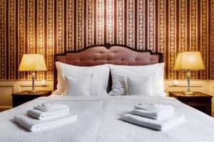 布拉格Hotel Praga 1885的一间卧室配有一张床,上面有两条毛巾