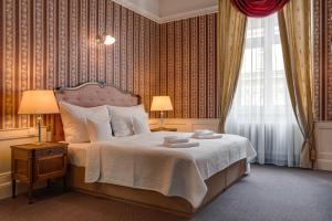 布拉格Hotel Praga 1885的一间卧室配有一张带两盏灯的床和一扇窗户。