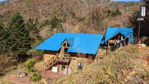 利根pension ぽかぽか（poka poka）的享有带蓝色屋顶的小木屋的顶部景致