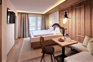迈尔霍芬内尔珀斯特酒店的一间卧室配有一张床、一张桌子和一张沙发