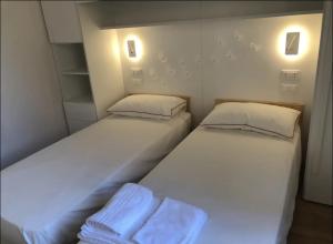 卡莫利Camogli Eden - Luxury apartment的配有白色墙壁的小客房内的两张床