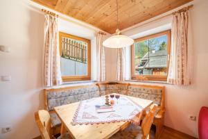 摩梭Egarthof Ferienwohnung Alpenrose的一间带桌椅和窗户的用餐室