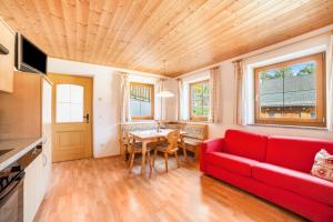 摩梭Egarthof Ferienwohnung Alpenrose的客厅配有红色的沙发和桌子
