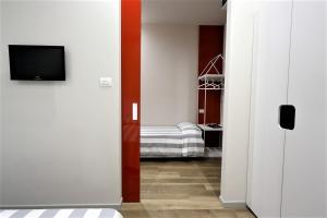 里米尼金叶酒店 的走廊上设有一张床和电视的房间