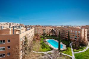 马德里Los Castaños Design Apartments in Conde Orgaz Area的享有公寓大楼的顶部景致,设有游泳池