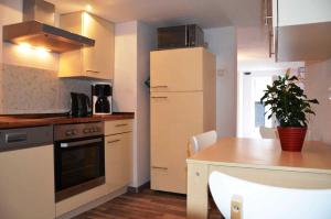 岑平Fewo Fischerhus的厨房配有桌子和白色冰箱。