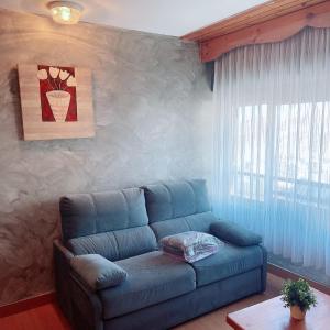 帕斯底拉卡萨Confortable Lake Placid的客厅设有蓝色的沙发和窗户。
