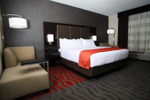门罗门罗智选假日套房酒店的酒店客房带一张大床和一把椅子