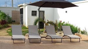 BonouaVilla Bolati, avec piscine, jacuzzi, jardin et vue的四把椅子和一把伞