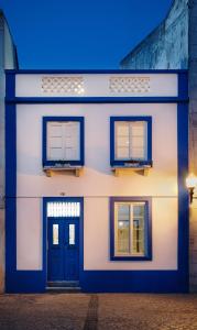 贝雅Casa Calmaria Beja的白色的房子,设有两扇窗户和一扇门