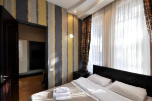 第比利斯Hotel Majestic的一间卧室设有一张床、一台电视和一个窗口。