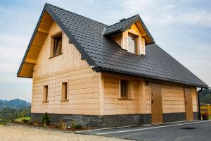 FalsztynDomki Falsztyn的一座带黑色屋顶的木制建筑