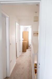 萨顿因阿什菲尔德Sutton House的一条有白色墙壁的走廊和一间带门的房间