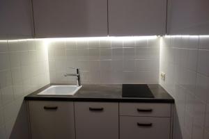 克拉科夫Sebastian Gold的厨房设有水槽和白色瓷砖墙。