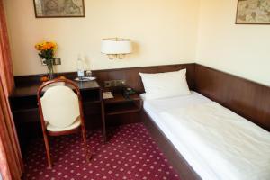 杜塞尔多夫豪斯艾美珠酒店的酒店客房配有一张床、一张桌子和一把椅子。