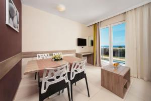 乌马格Apartments Katoro Plava Laguna的一间带桌椅和大窗户的用餐室