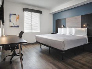 韦伯斯特stayAPT Suites Houston-NASA/Clear Lake的一间卧室配有一张床、一张桌子和一张桌子