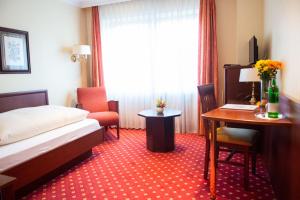 杜塞尔多夫豪斯艾美珠酒店的配有一张床、一张桌子和一张桌子的酒店客房