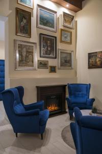 博洛尼亚Albergo Rossini 1936 - Small & Charming的客厅配有蓝色椅子和壁炉