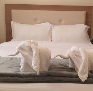 NarokWalabi Mara Hotel的床上的两条毛巾,上面有两只填满动物