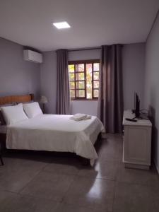 莫雷蒂斯Armazém do Porto, Chalé Azaléia的一间卧室设有一张大床和一个窗户。