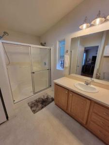 克拉马斯福尔斯Crater Lake Gateway-Rocky Point Resort的带淋浴、盥洗盆和镜子的浴室